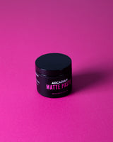 Arcadian Matte Paste, Tiegel aus einem Winkel vor magentafarbenem Hintergrund